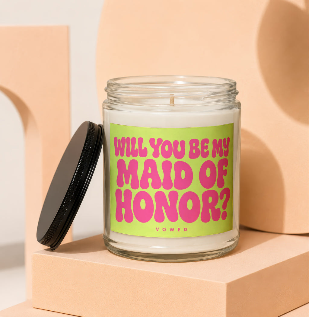Glass candle with a lime green label asking "Will You Be My Maid of Honor?"