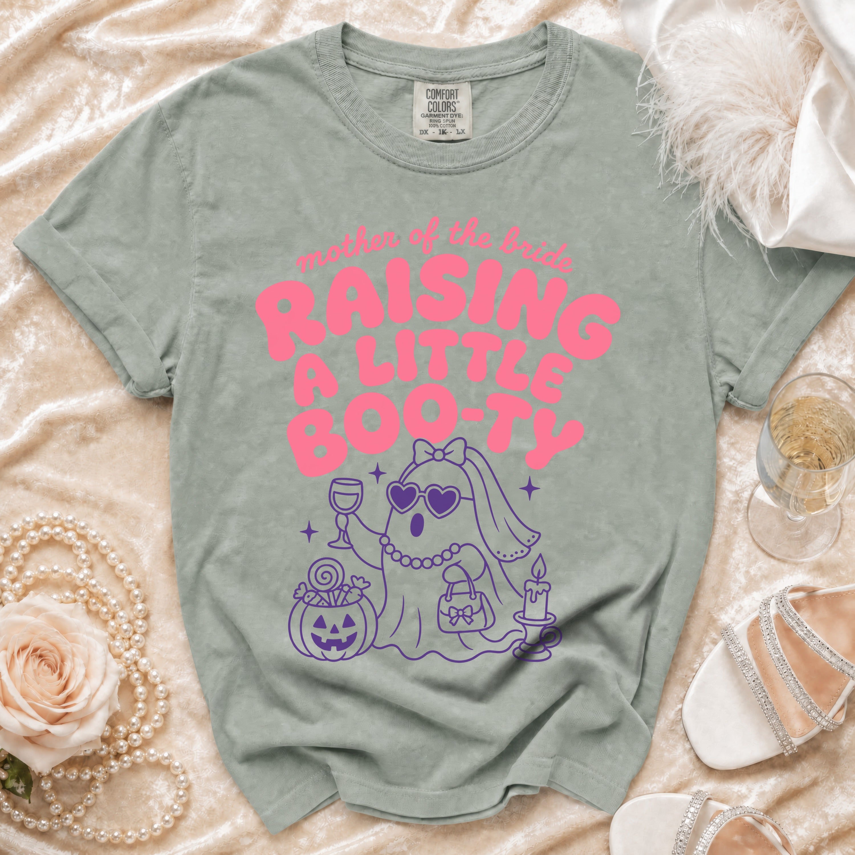 Light green t-shirt with pink "Mother of the Bride Raising a Little Boo-ty" graphic.