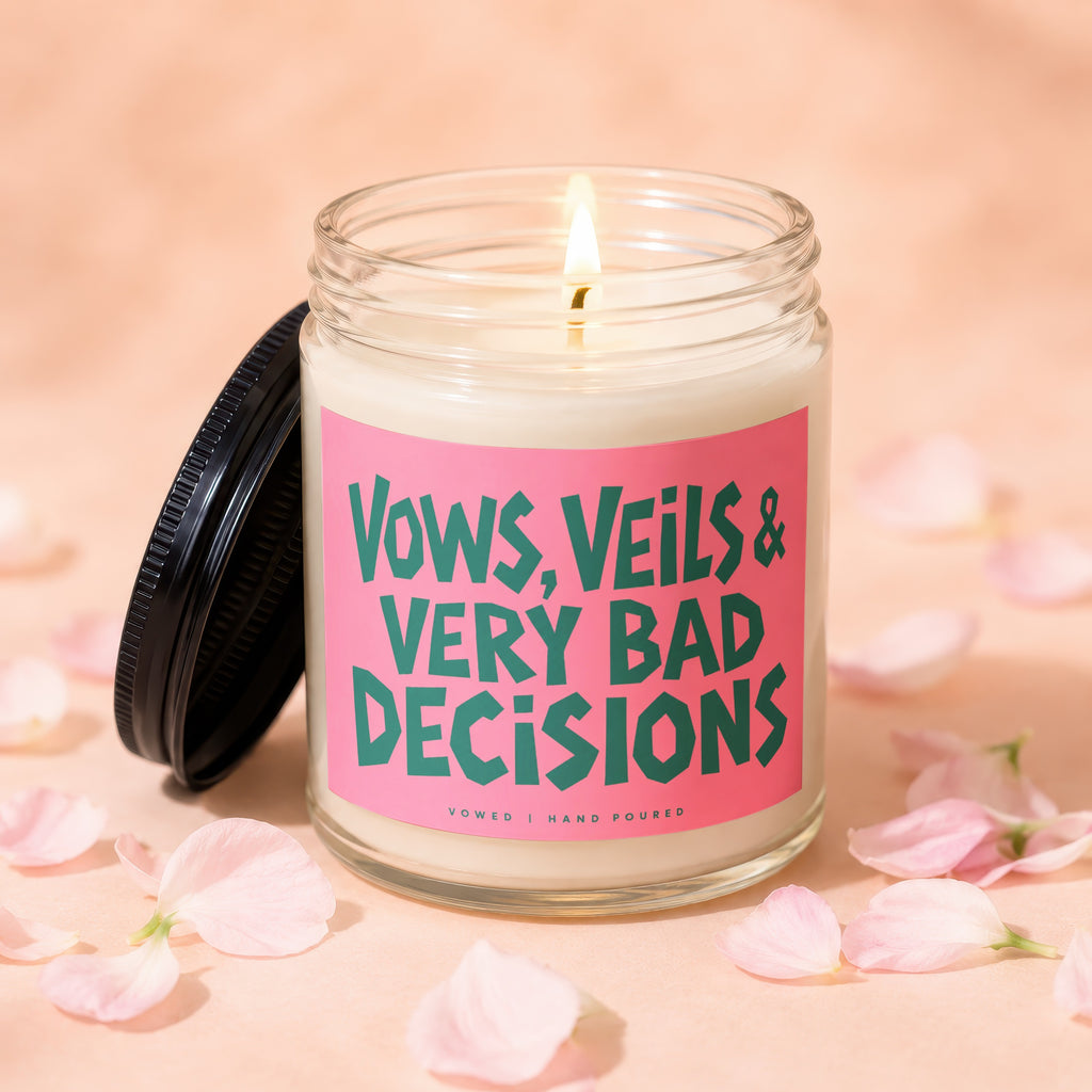 Candle with "Vows, Veils & Very Bad Decisions" text and a lit wick.