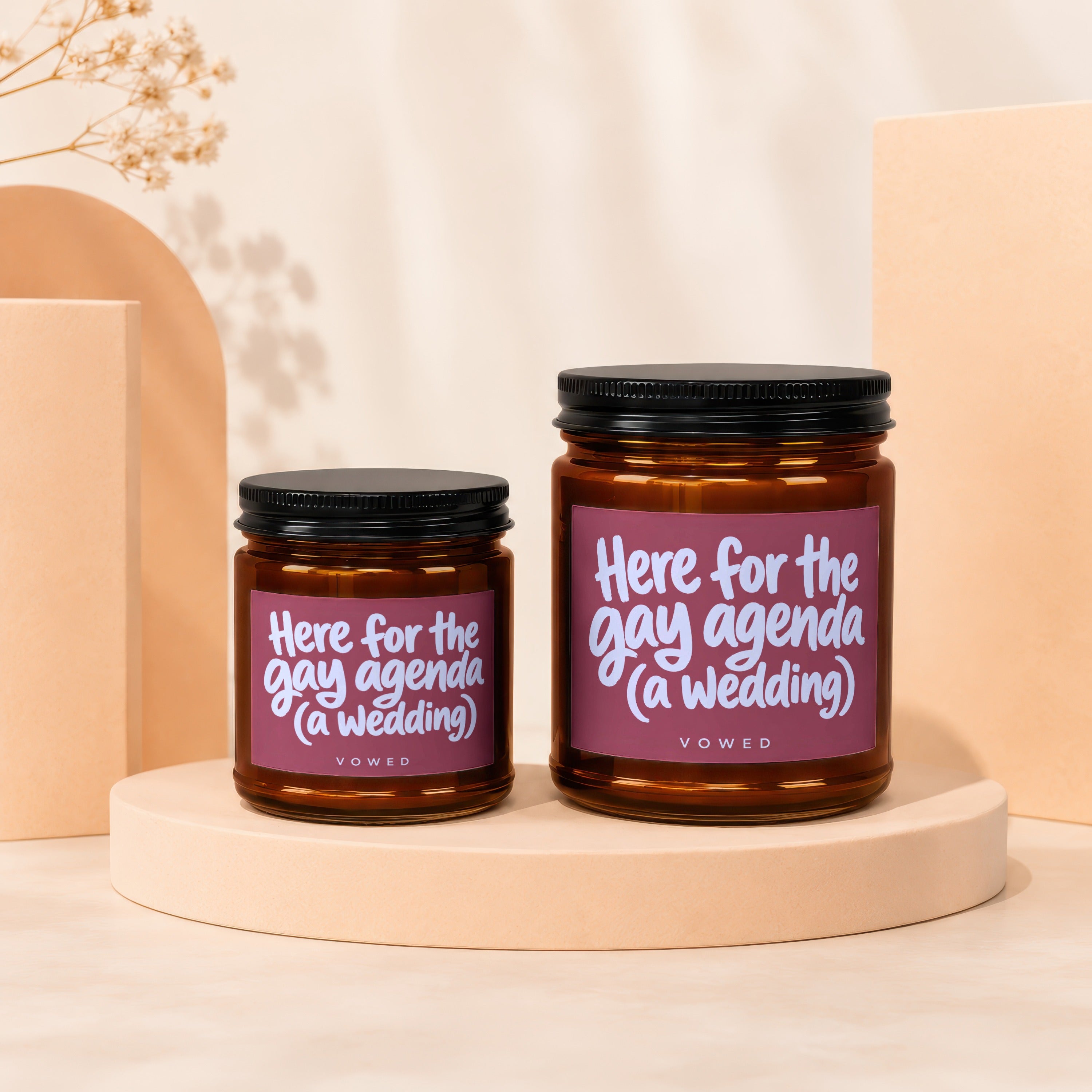 Two candles with labels reading "Here for the gay agenda (a wedding)".