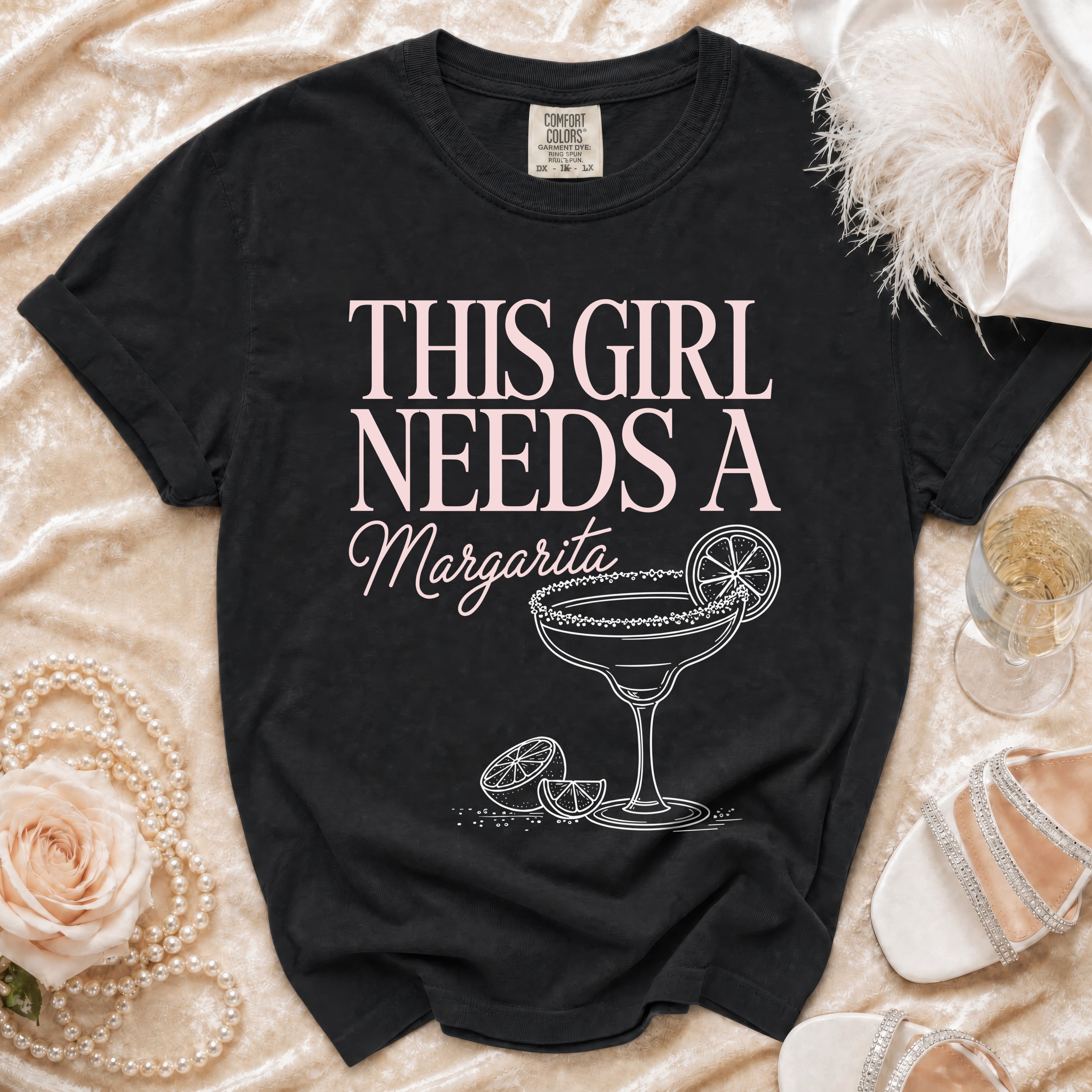 Black t-shirt with "This Girl Needs a Margarita" text and margarita graphic.