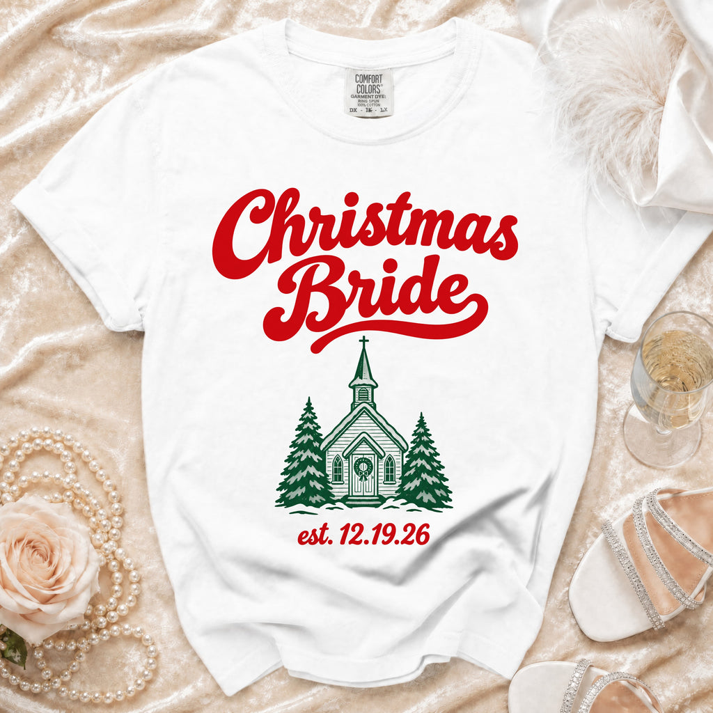 White t-shirt featuring red Christmas Bride text and a green church graphic with pine trees.