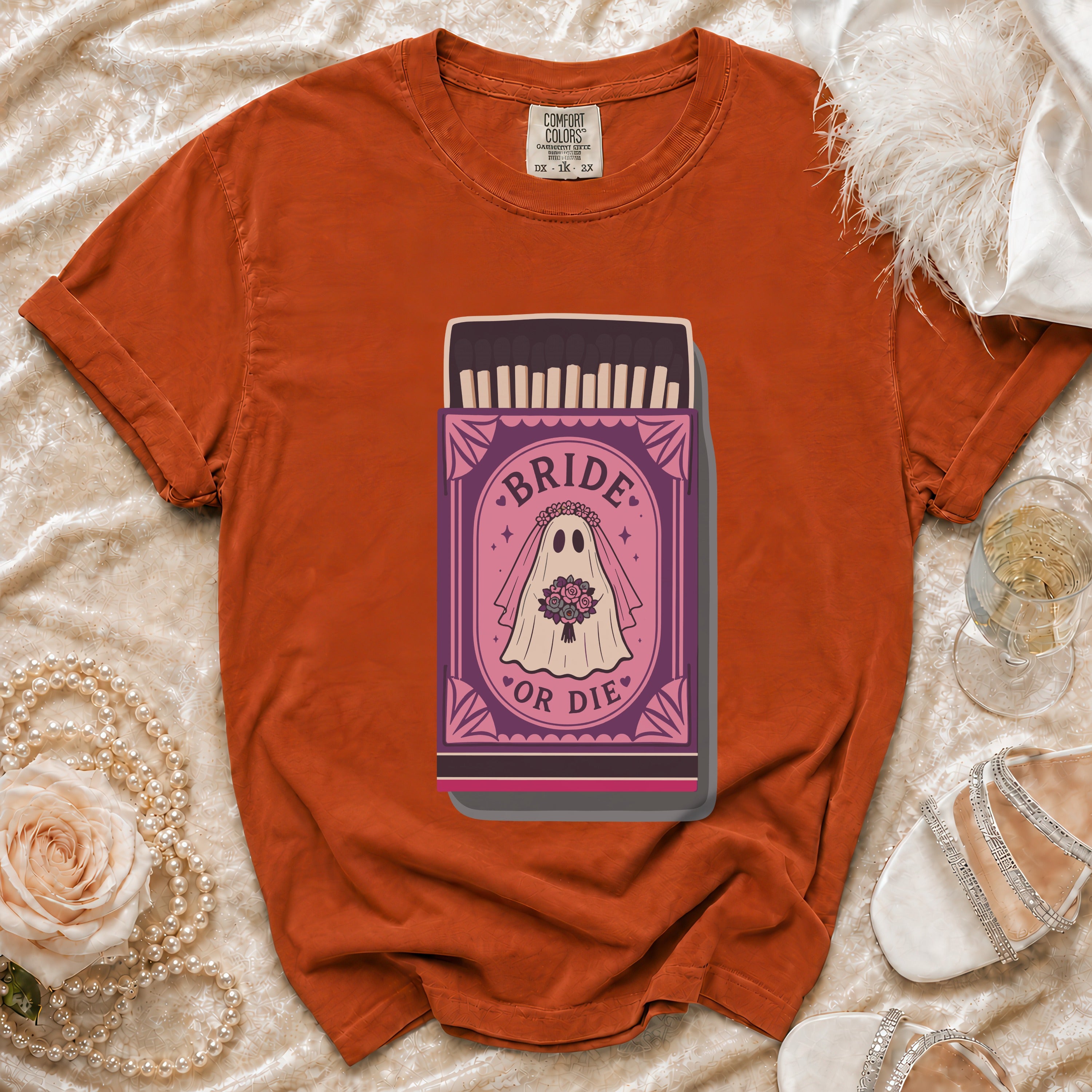 Orange t-shirt with "Bride or Die" ghost graphic on a matchbox.
