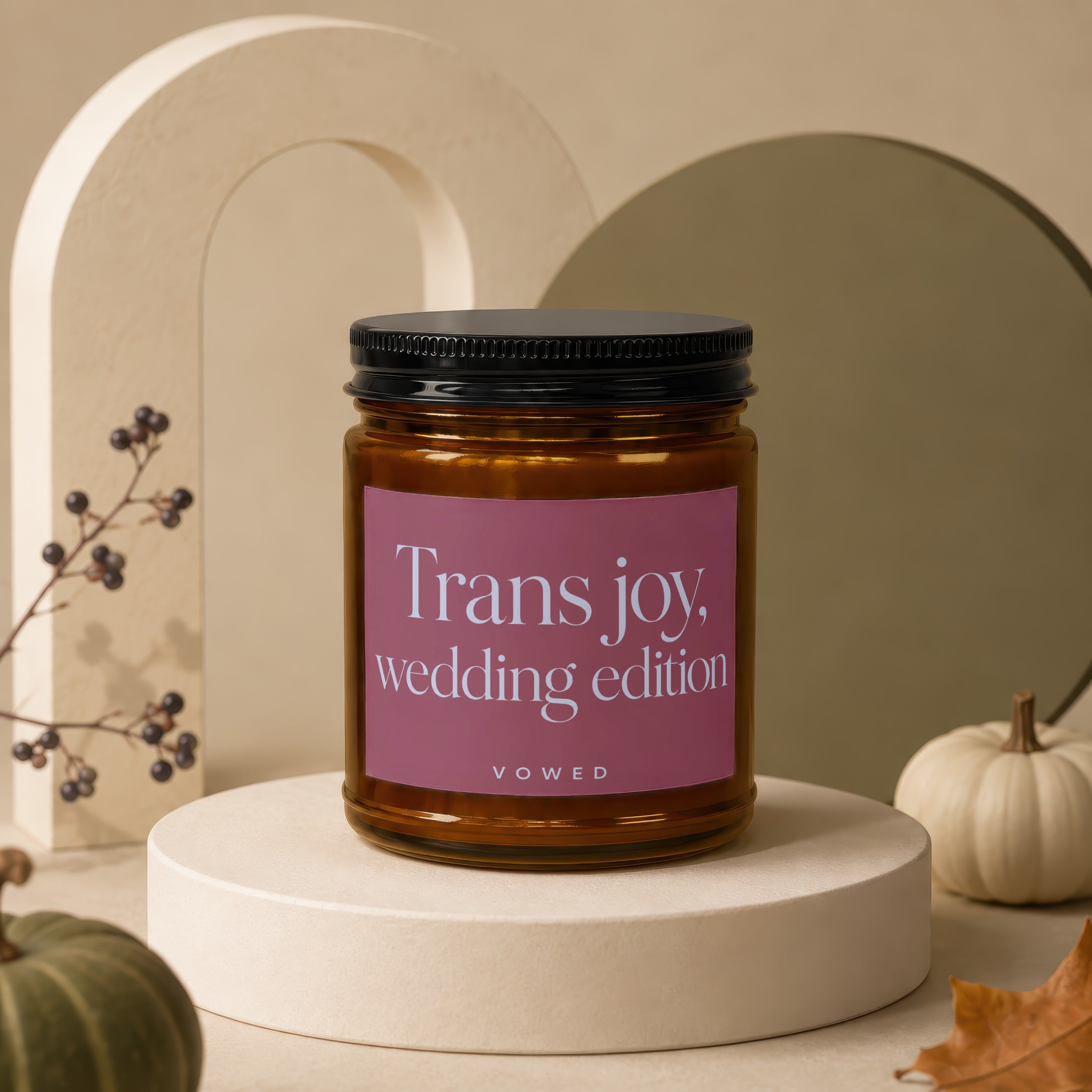 Amber candle in glass jar with pink label reading "Trans joy, wedding edition Vowed".