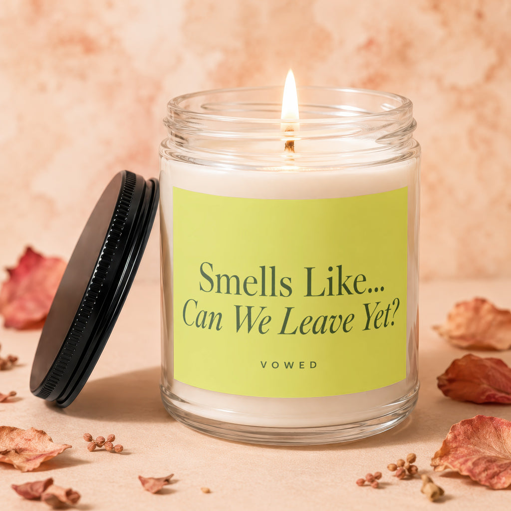 Lit candle in glass jar with green label reading "Smells Like... Can We Leave Yet? VOWED".