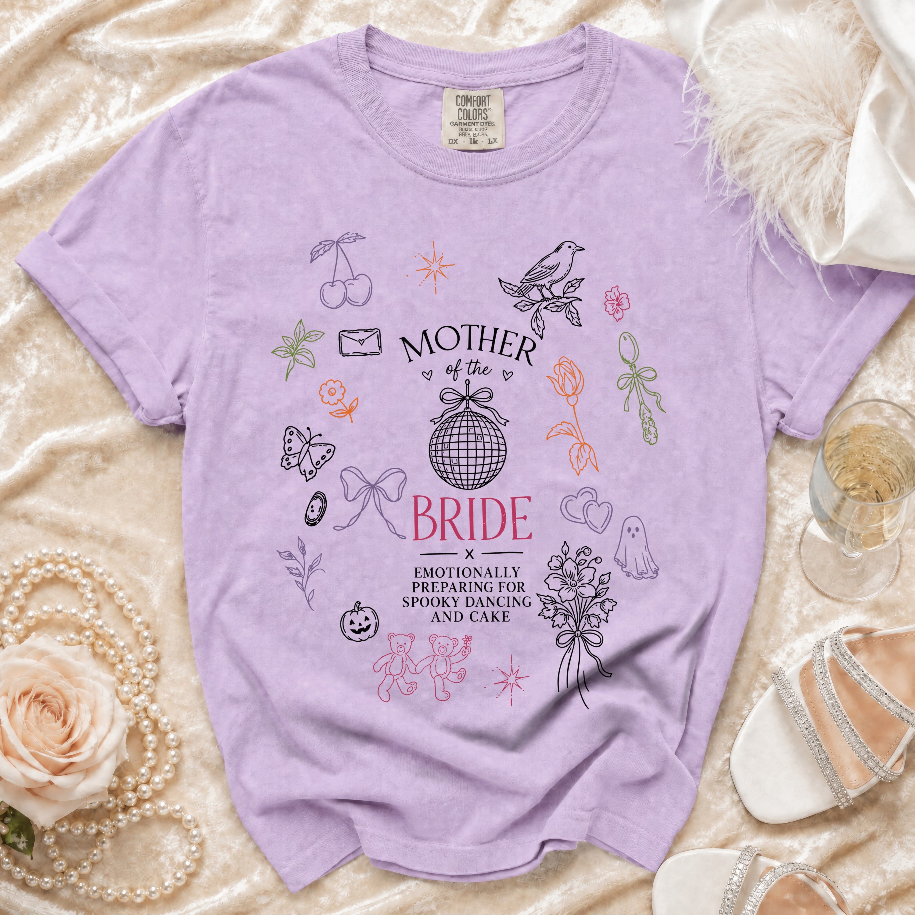 Lavender t-shirt with "Mother of the Bride" and "Emotionally preparing for spooky dancing and cake" text.