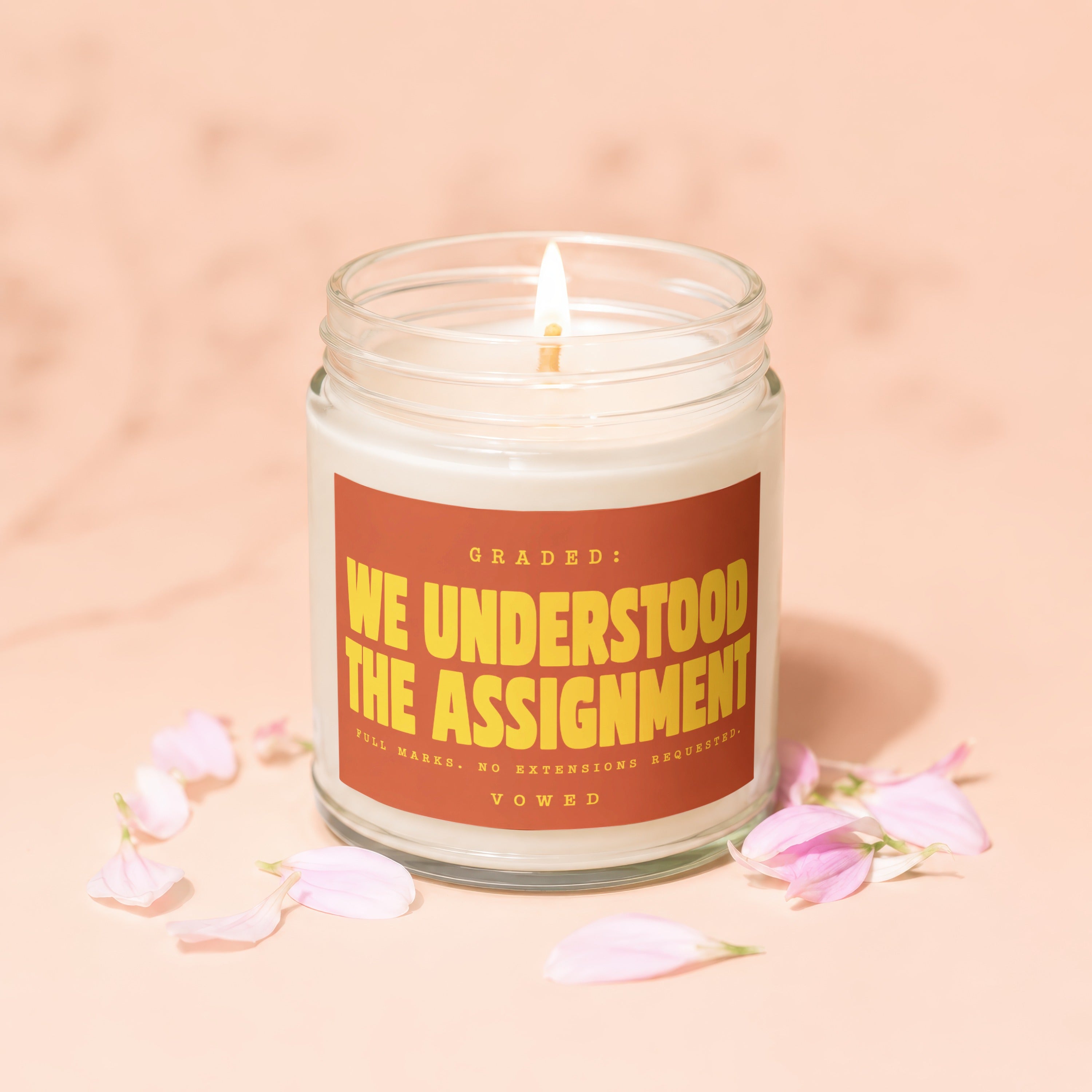 Candle with text "Graded: We Understood the Assignment. Full Marks. No Extensions Requested. Vowed."