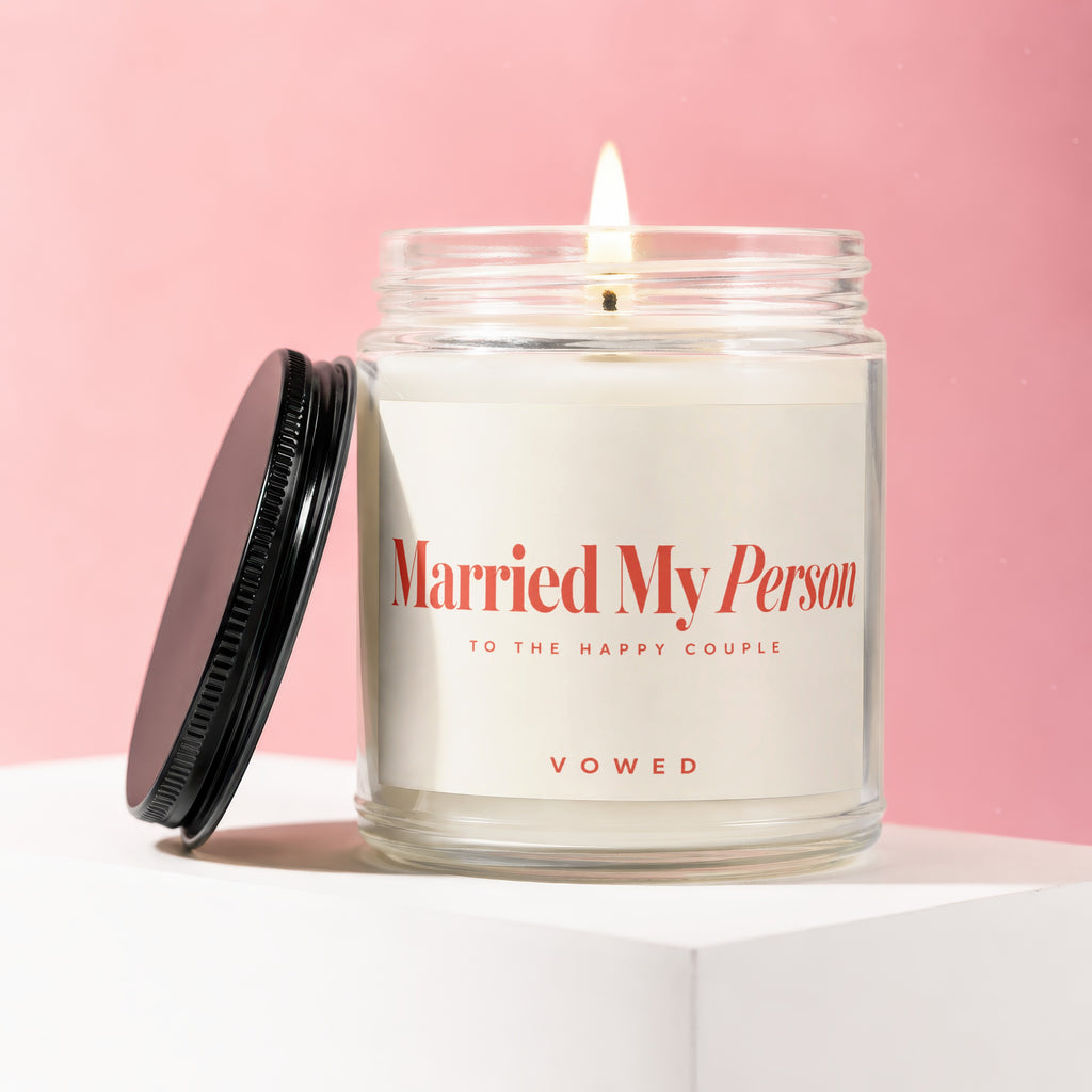 Jar candle with lit wick, label reads "Married My Person," "To the Happy Couple," "Vowed."