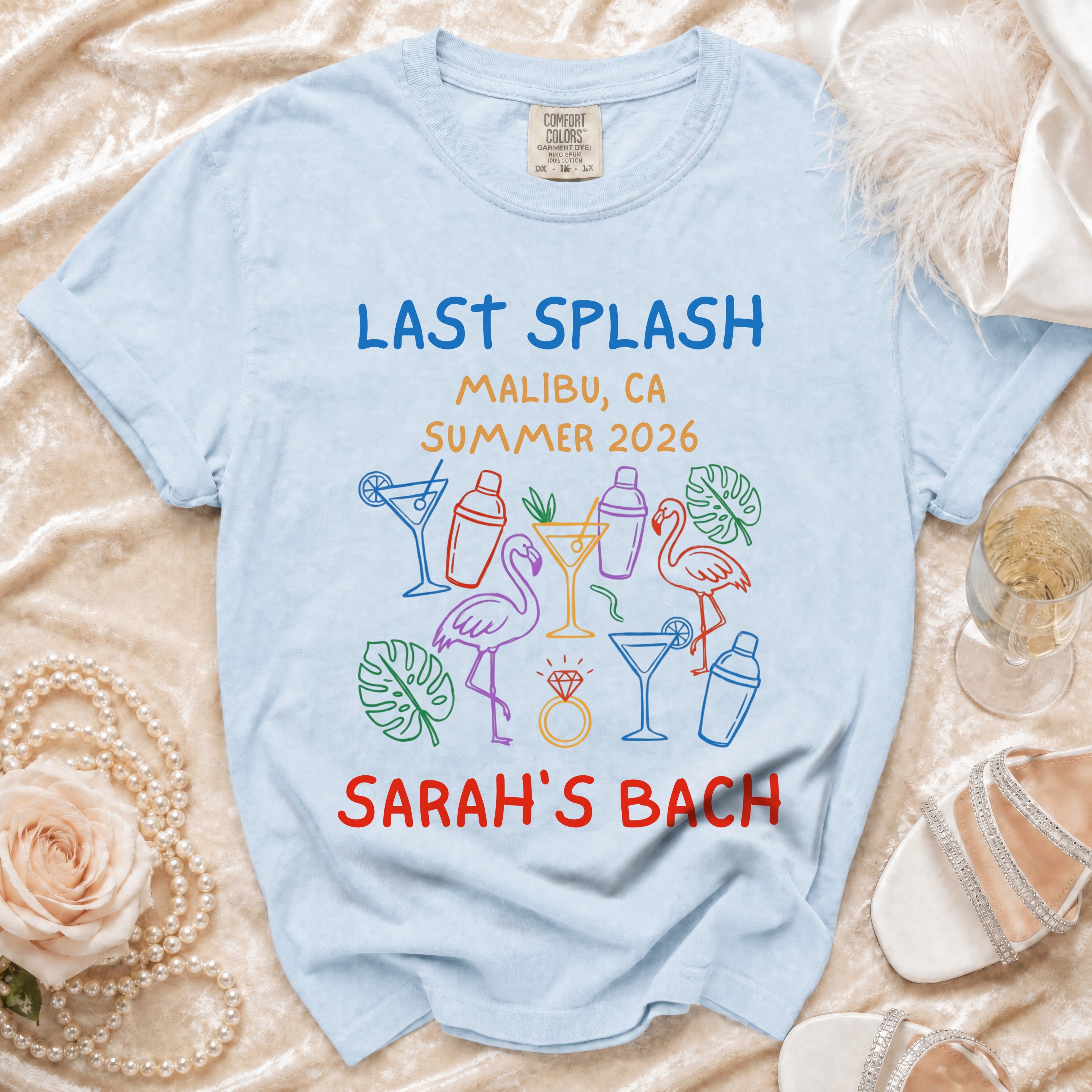 Light blue t-shirt with "Last Splash Malibu, CA Summer 2026 Sarah's Bach" text and graphics.