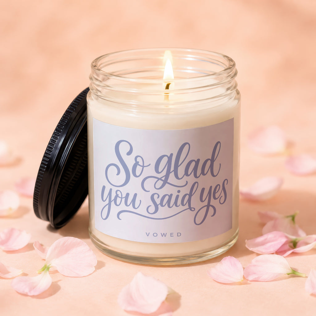 Jar candle with lit wick and lid off, "So glad you said yes" text.