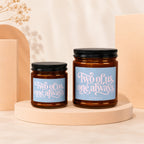 Two amber glass candles, one larger, with labels reading "Two of us, one always".