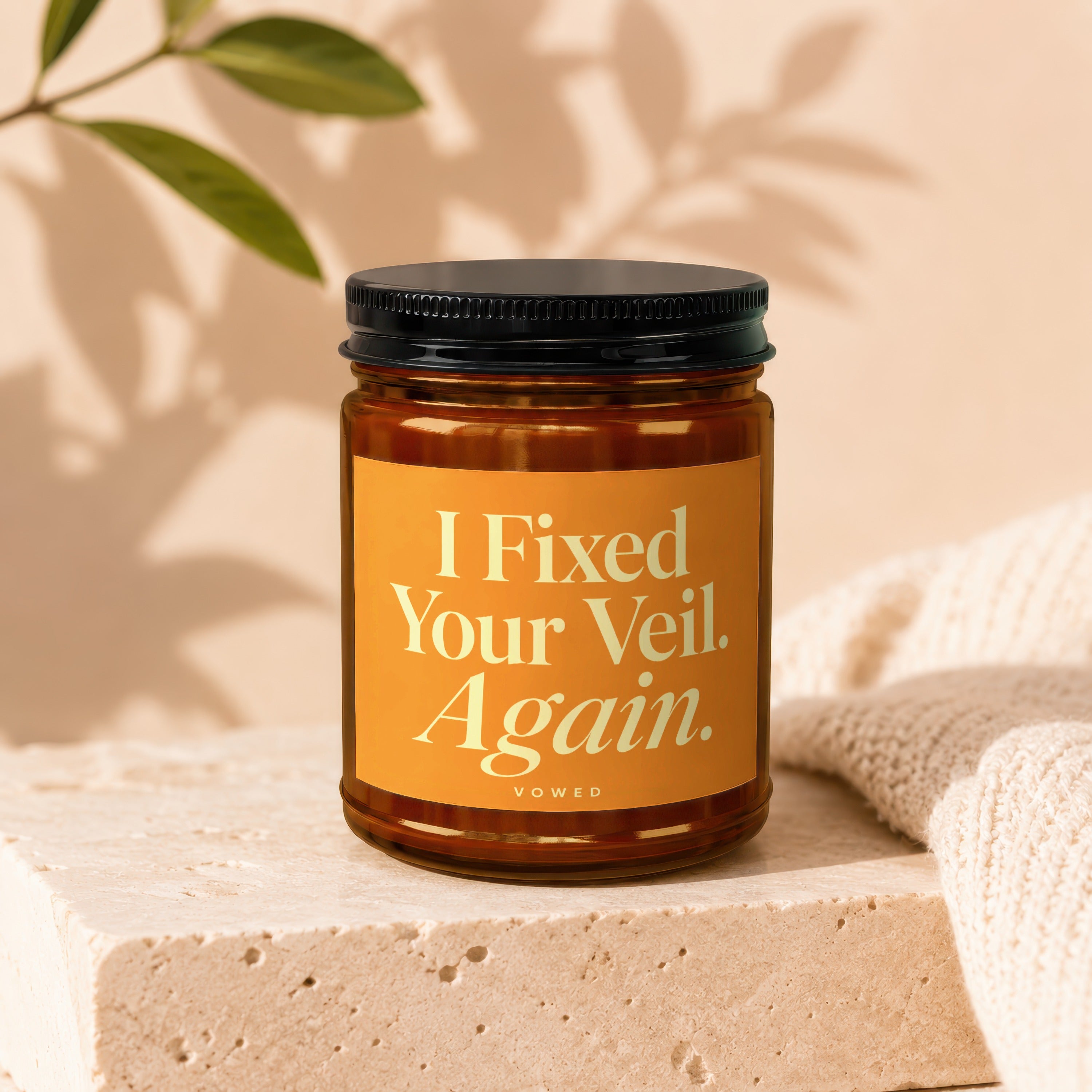 Amber jar candle with orange label reading "I Fixed Your Veil. Again. VOWED."
