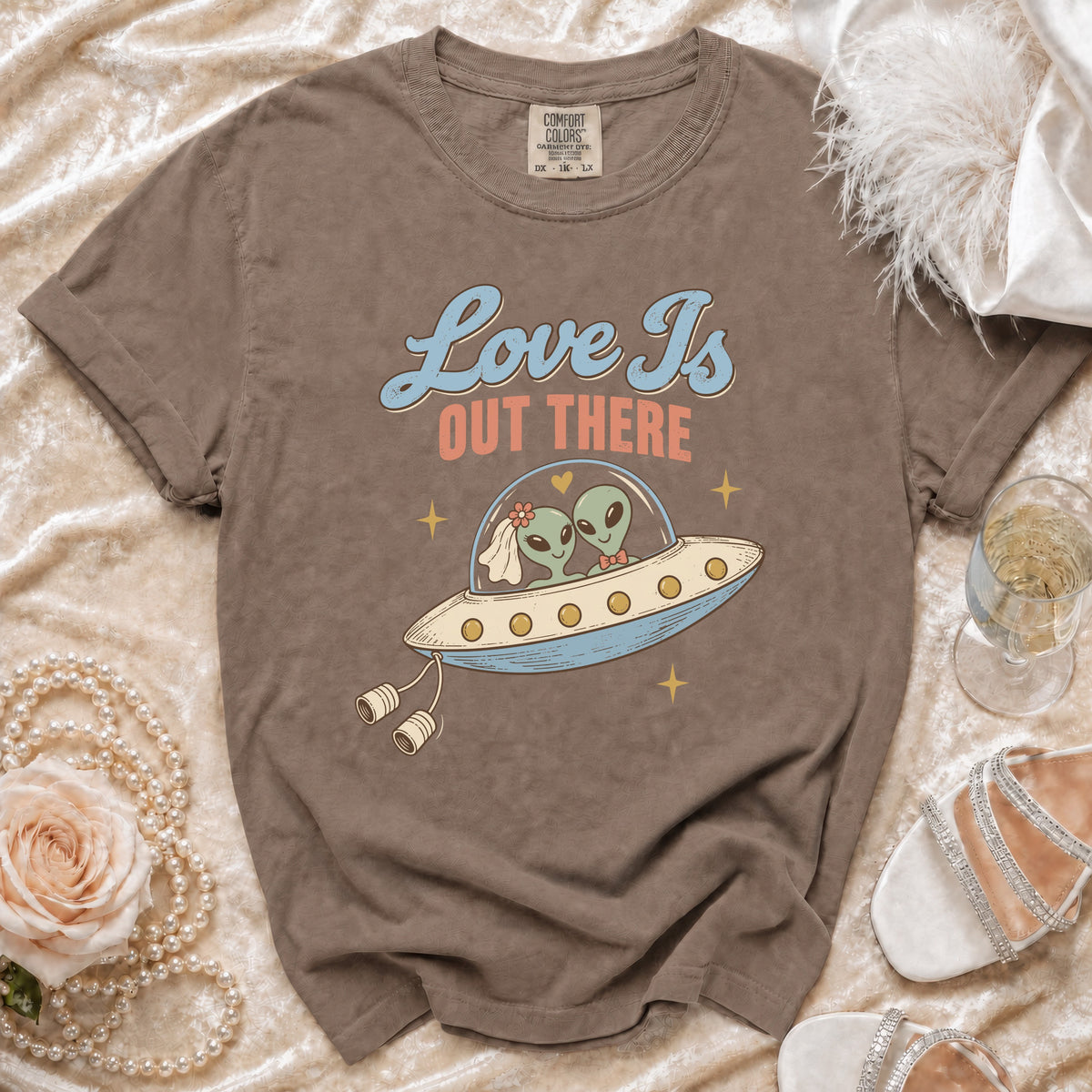 T-shirt graphic of aliens in a UFO with text "Love Is Out There".