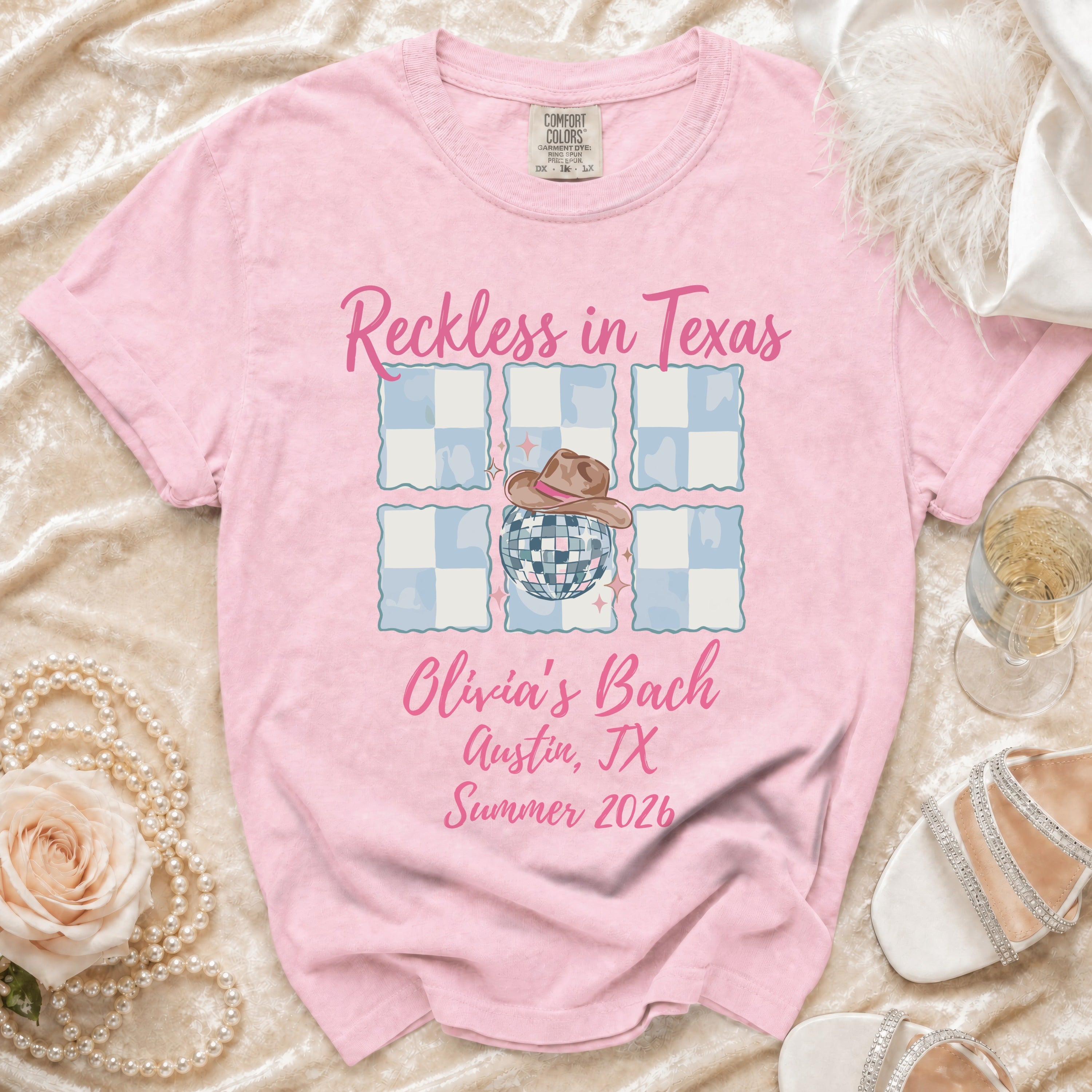 Pink t-shirt with "Reckless in Texas Olivia's Bach Austin, TX Summer 2026" text.