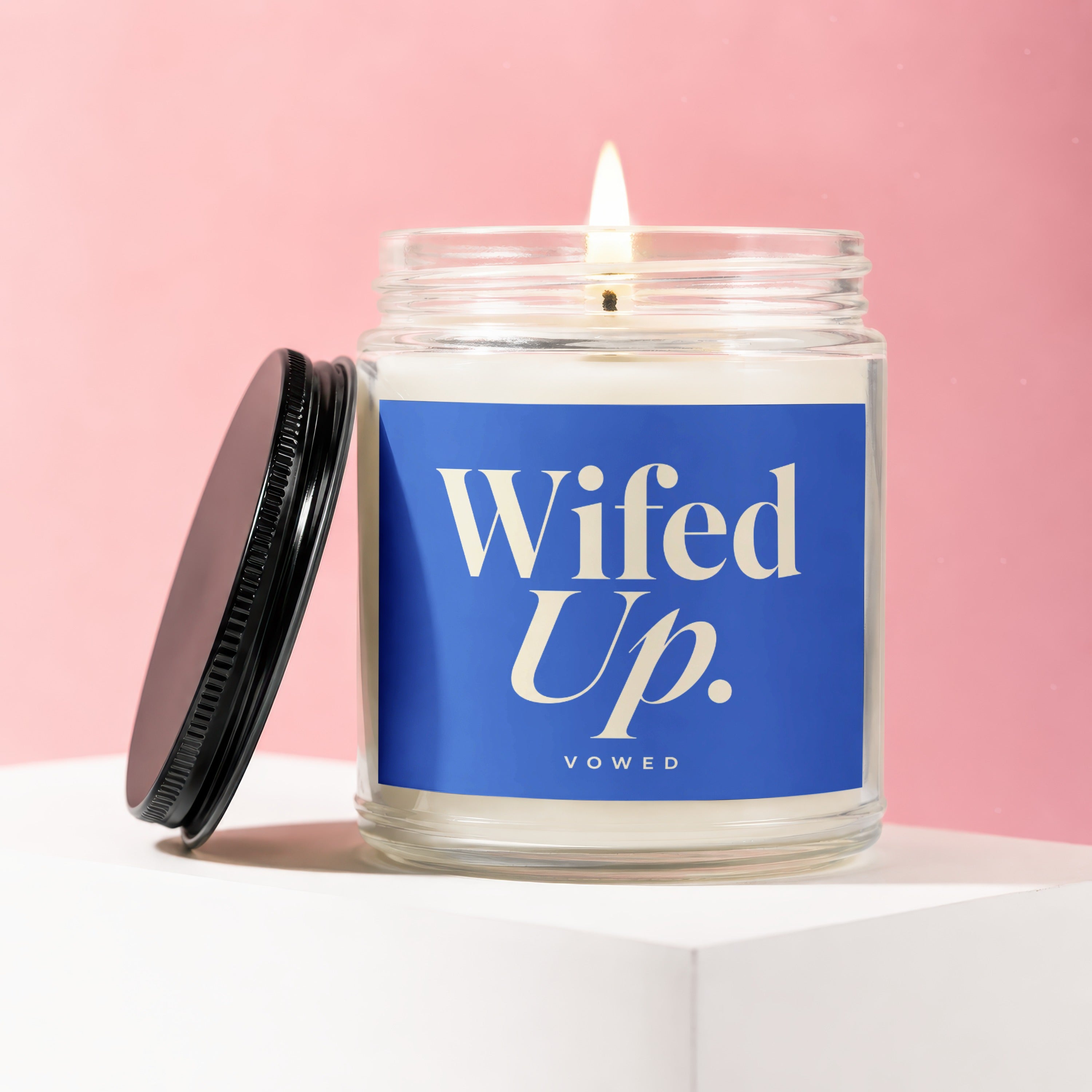 Wifed Up candle in glass jar with black lid on pink background