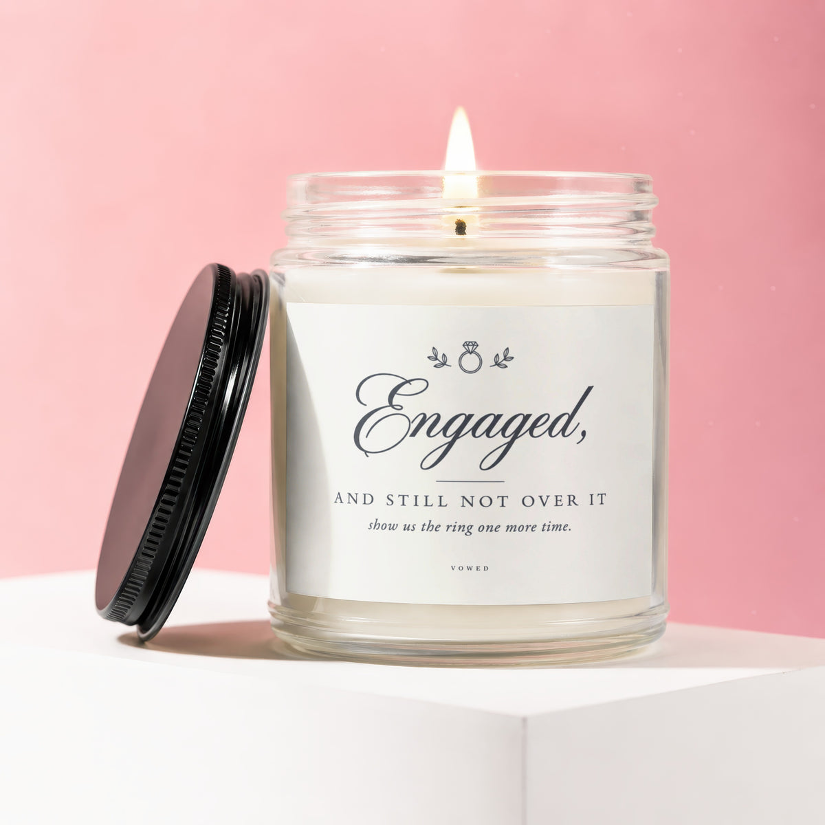 Engaged, and still not over it candle in a glass jar with lit wick.