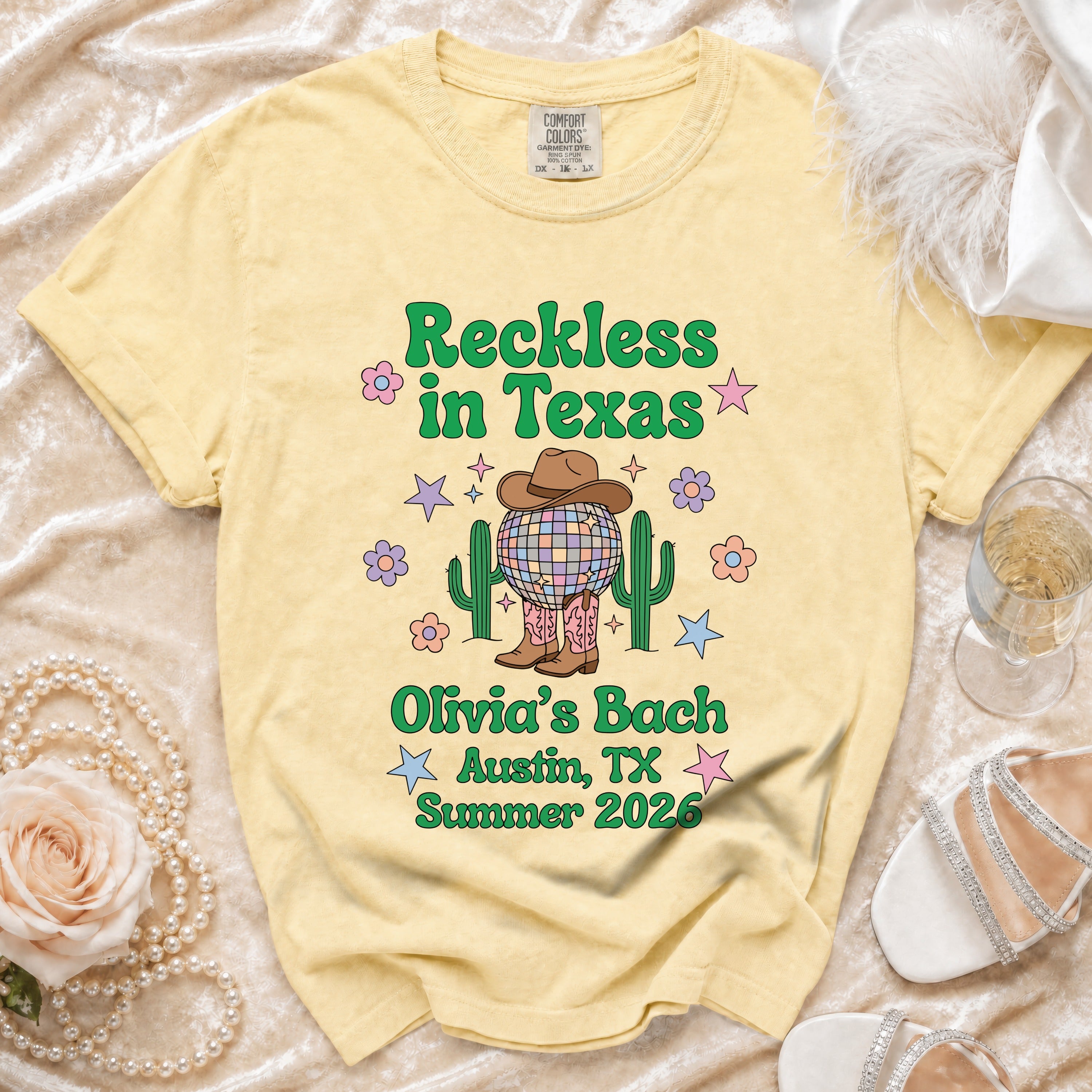 Yellow t-shirt with "Reckless in Texas Olivia's Bach Austin, TX Summer 2026" and disco ball cactus graphic.
