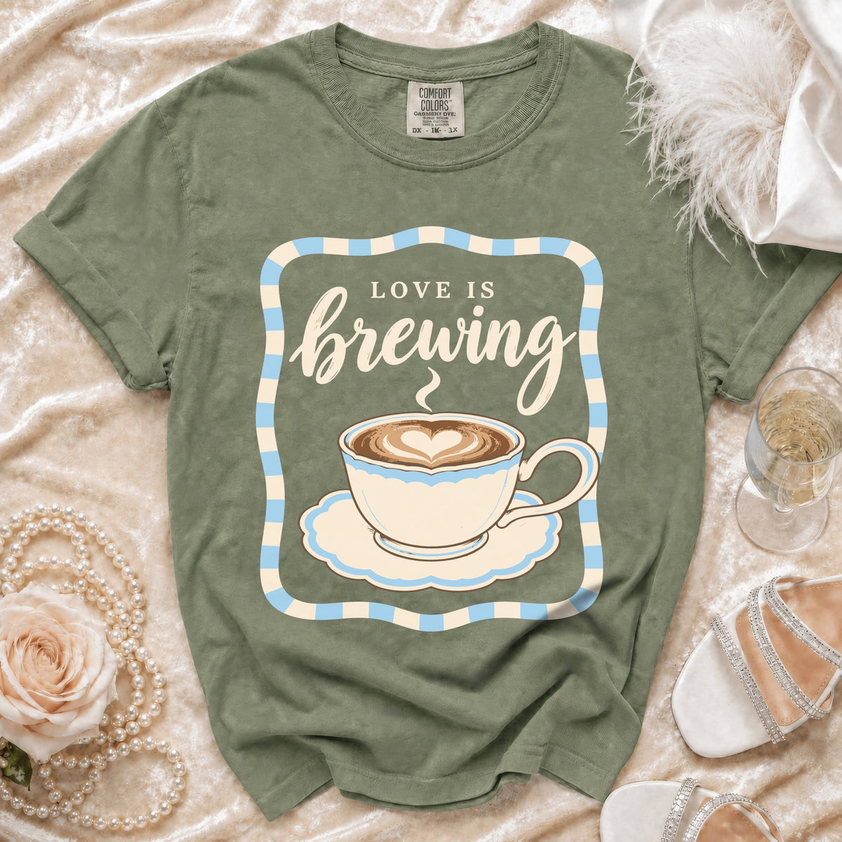 Olive green t-shirt with "Love Is Brewing" and coffee cup graphic.