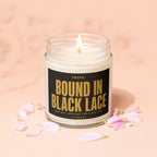 Candle with lit wick and label text "SWORN: BOUND IN BLACK LACE".