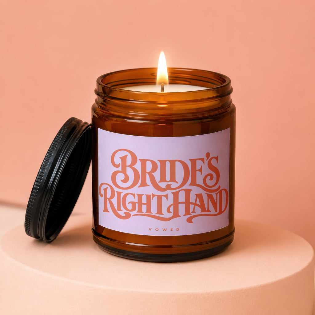 Amber jar candle lit, with label reading "BRIDE'S RIGHT HAND VOWED".