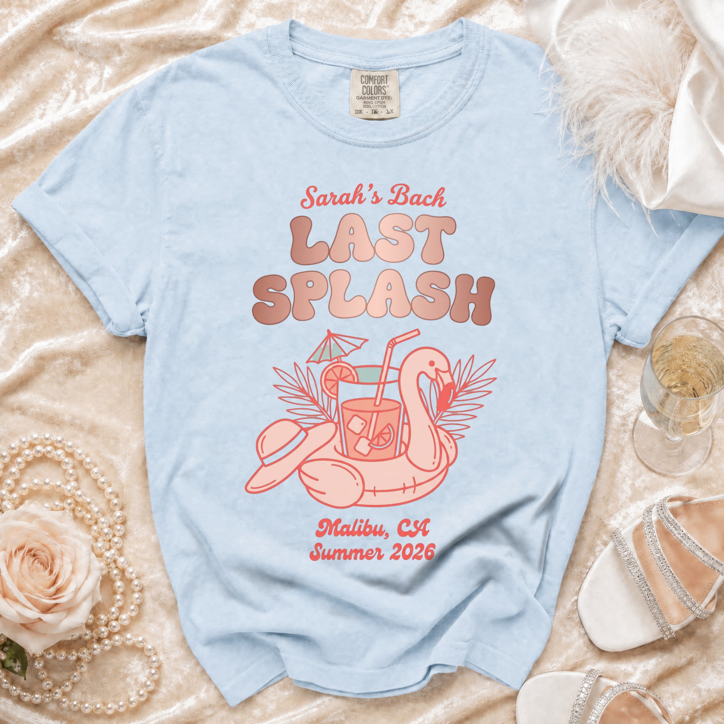 Light blue t-shirt with "Sarah's Bach LAST SPLASH Malibu, CA Summer 2026" and flamingo graphic.