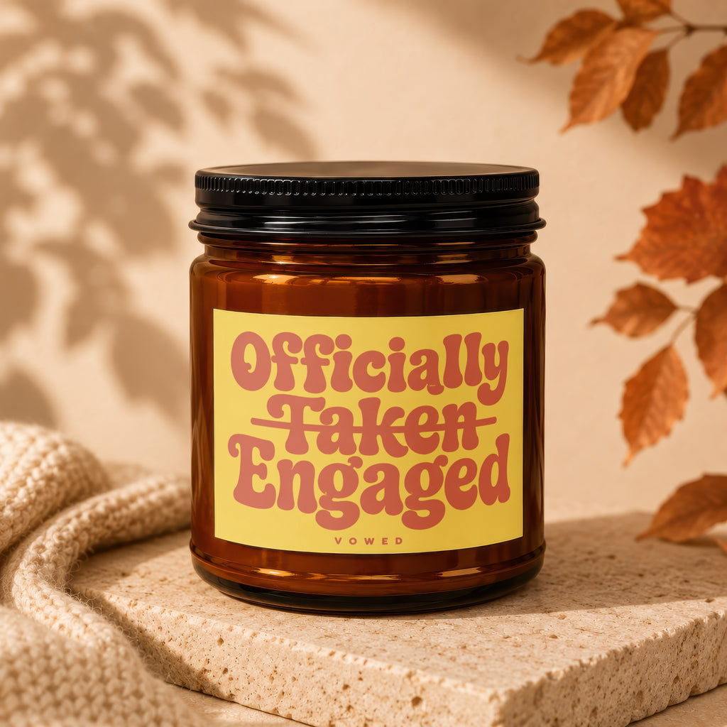 Brown glass candle with yellow label reading "Officially Taken Engaged Vowed".