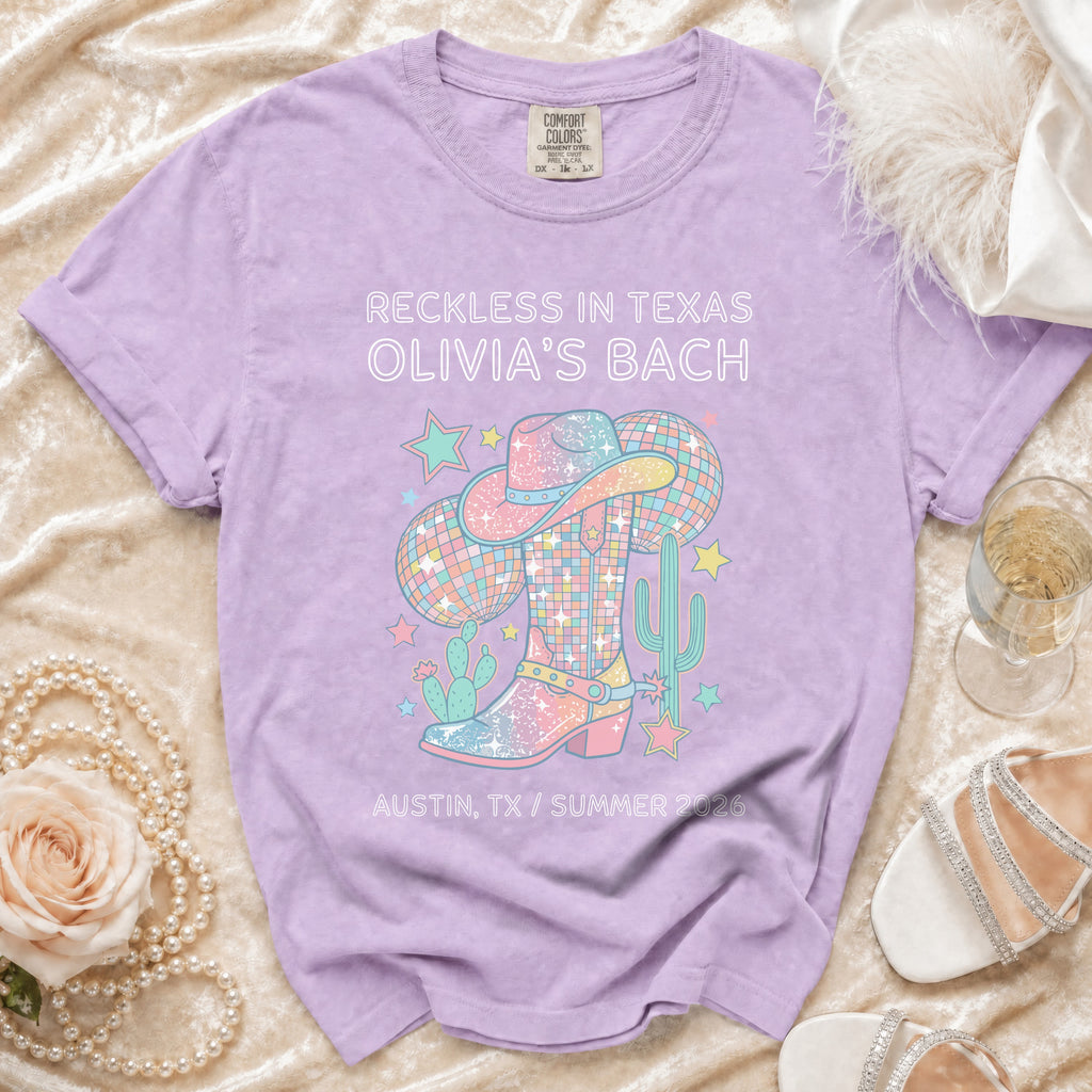 Purple t-shirt with "Reckless in Texas Olivia's Bach" and cowboy theme graphic.