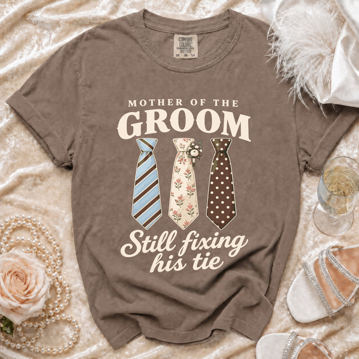 Brown t-shirt with "Mother of the Groom Still Fixing His Tie" and three ties.