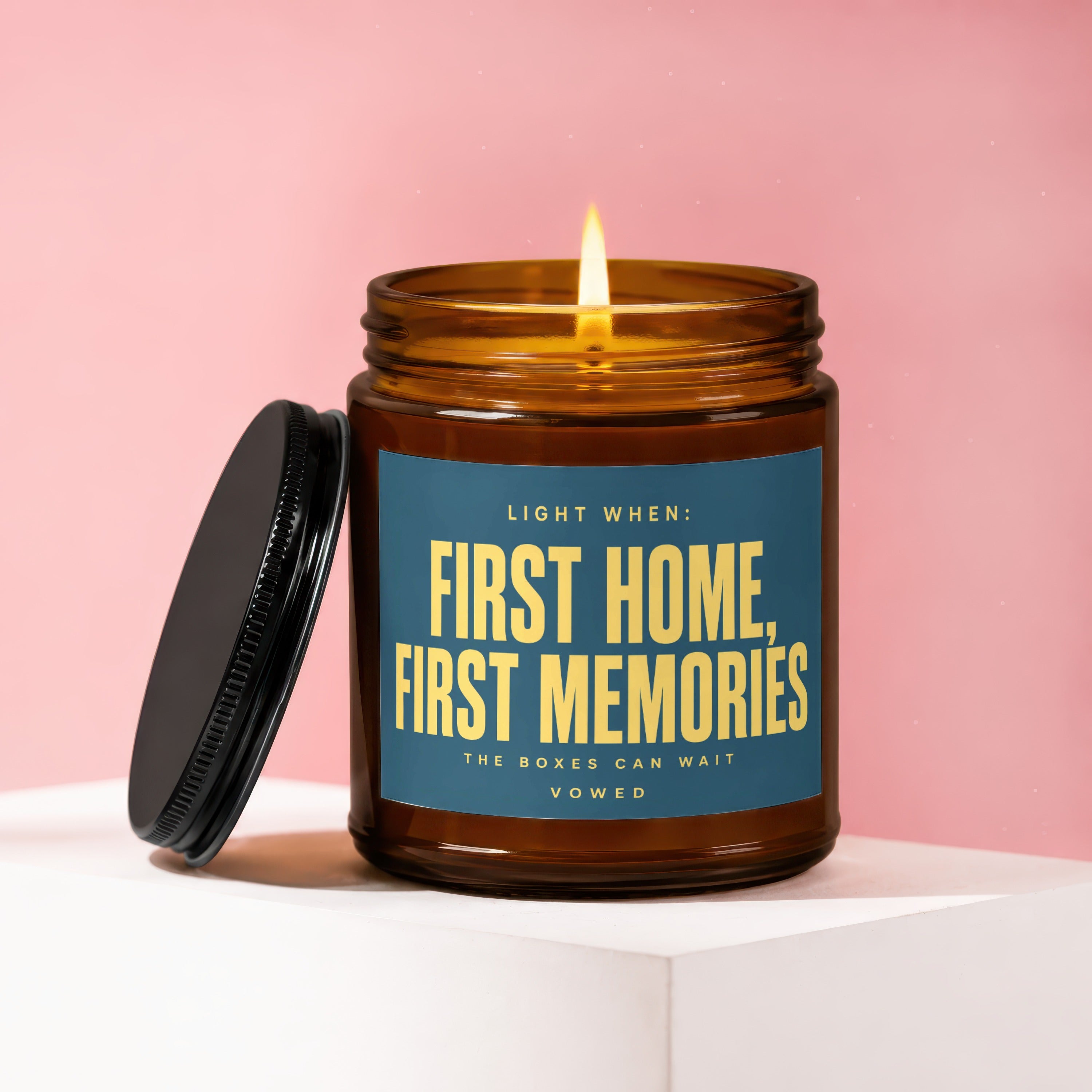 Amber jar candle with lit flame, says "First Home, First Memories"