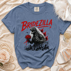 Blue t-shirt with Bridezilla Godzilla graphic, holding bouquet over city skyline.