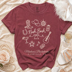A maroon short-sleeve t-shirt with white outline graphics and text reading Nash Bash and Madison's Bachelorette Nashville TN.