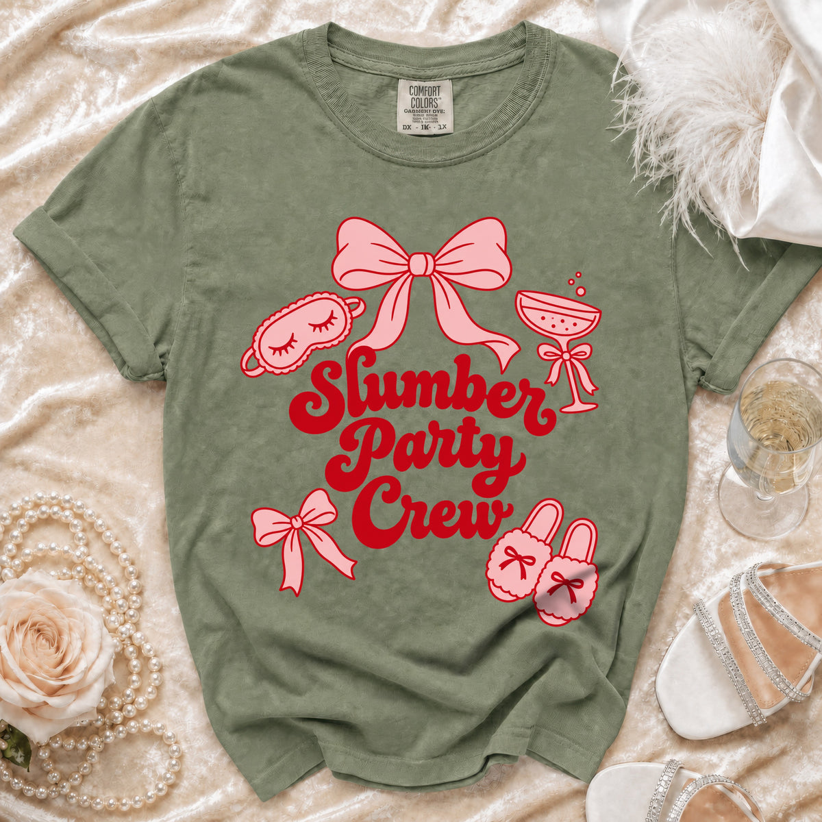 Olive green t-shirt with "Slumber Party Crew" text and graphic icons.