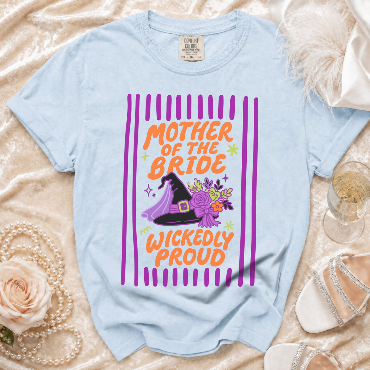 Light blue t-shirt with "Mother of the Bride Wickedly Proud" text and witch hat graphic.