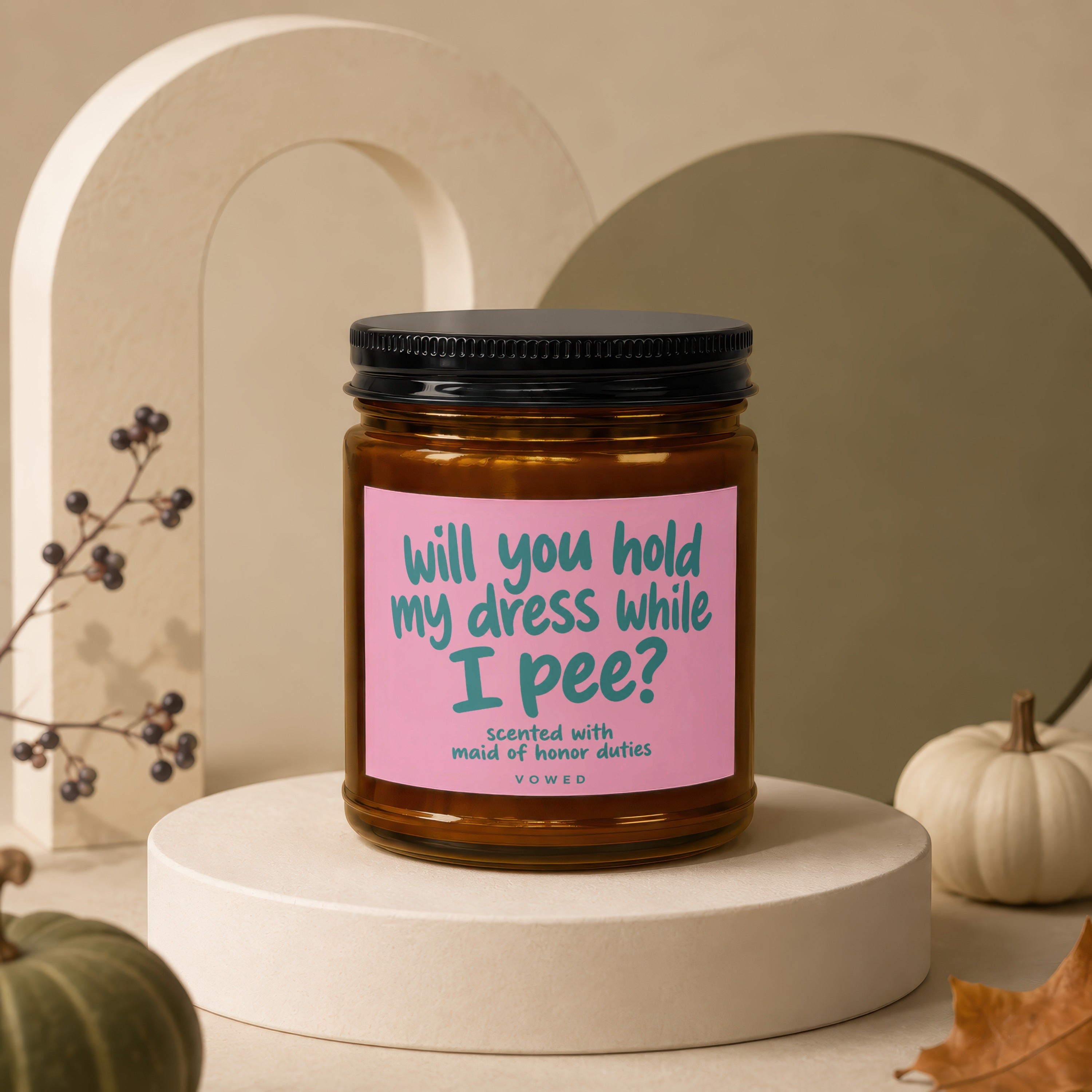 Scented candle with pink label asking, "will you hold my dress while I pee?"