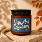 Amber candle with "Gay Ass Wedding VOWED" text on a blue label.
