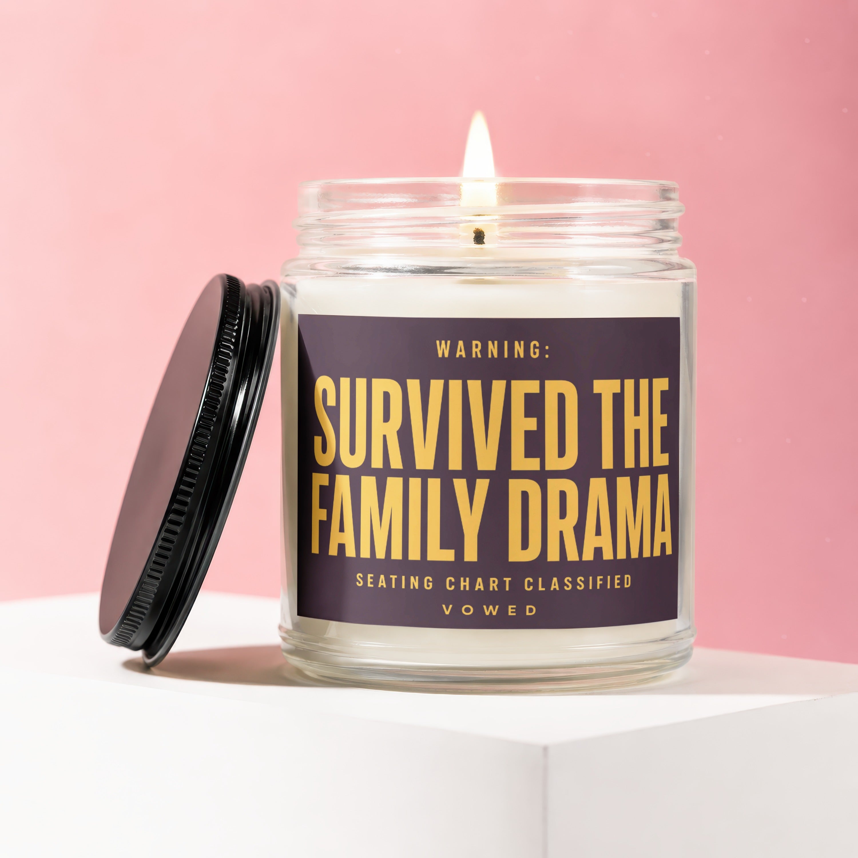 Jar candle with label reading "WARNING: SURVIVED THE FAMILY DRAMA SEATING CHART CLASSIFIED VOWED".