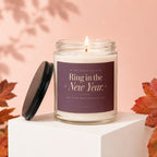 Glass candle with lid off, reading "Ring in the New Year."