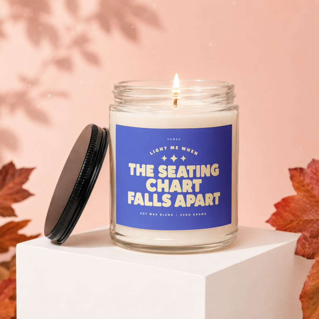 Glass candle with blue label reading "Light Me When The Seating Chart Falls Apart."