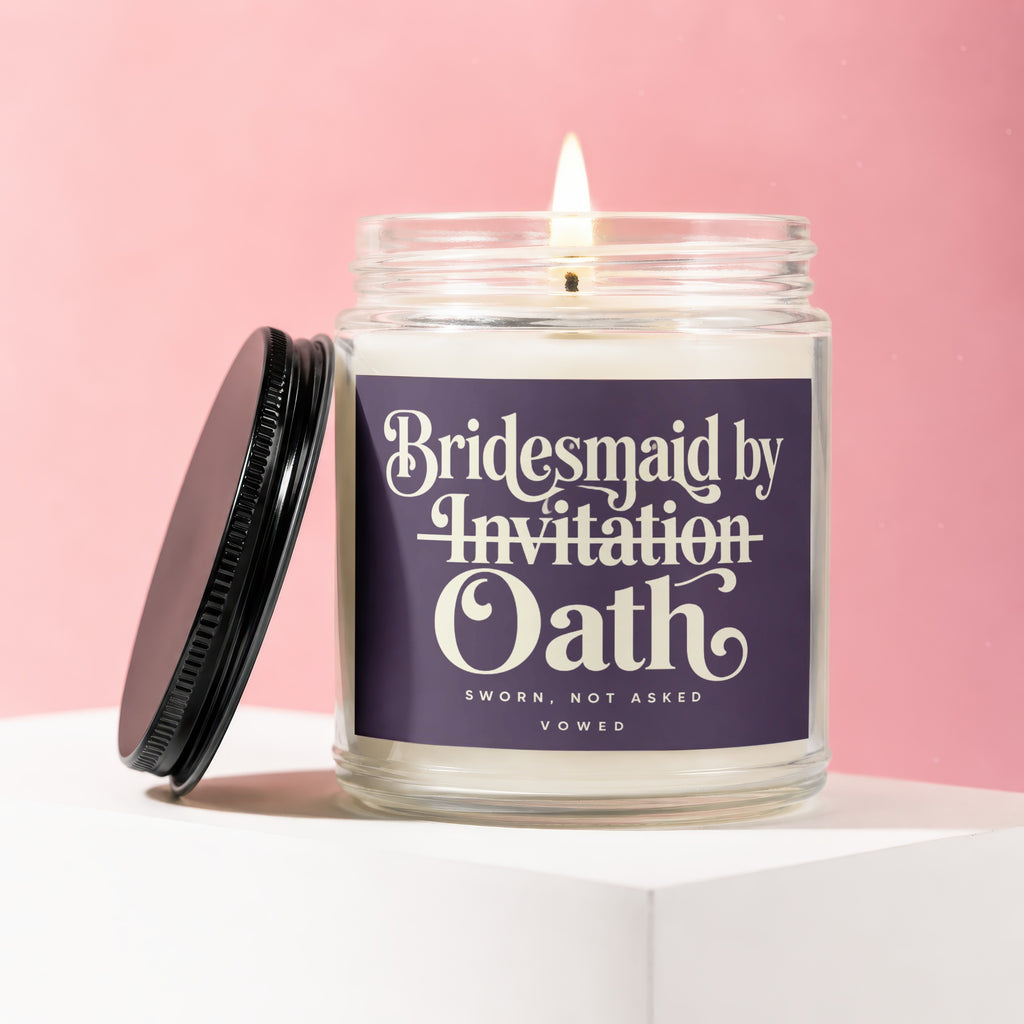 Glass candle with lit wick, lid ajar, labeled "Bridesmaid by Invitation Oath".