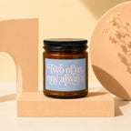 Amber glass candle with "Two of us, one always" text on a light blue label.