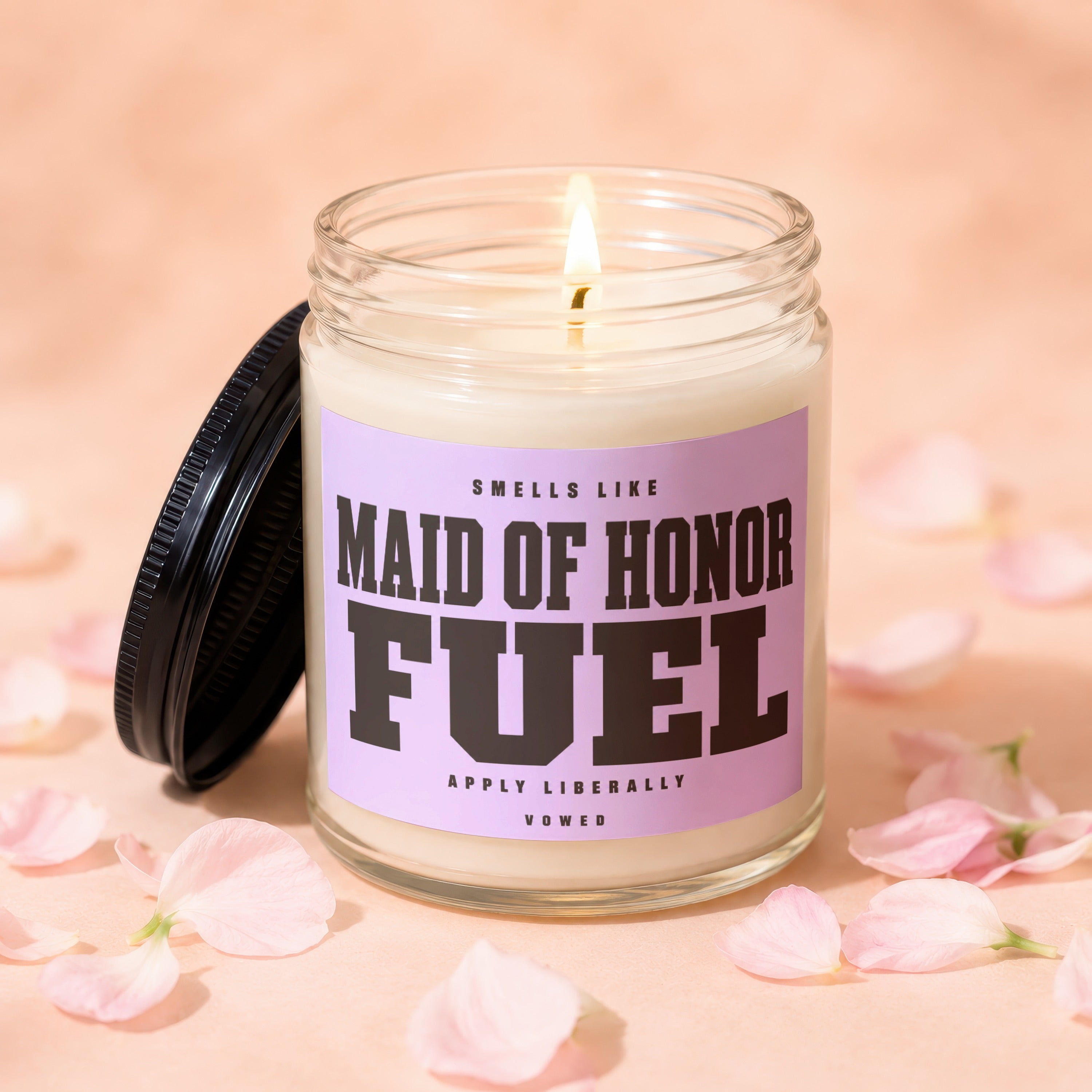 Candle with "Maid of Honor Fuel" text on a pink label and a lit wick.