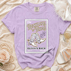 Purple t-shirt with "Reckless in Texas" graphic featuring cowboy boots.