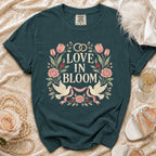 Teal t-shirt with "Love in Bloom" text, floral design, and two doves.