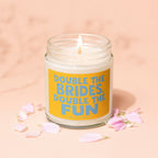 Lit candle in glass jar with yellow label reading "Double the Brides, Double the Fun."