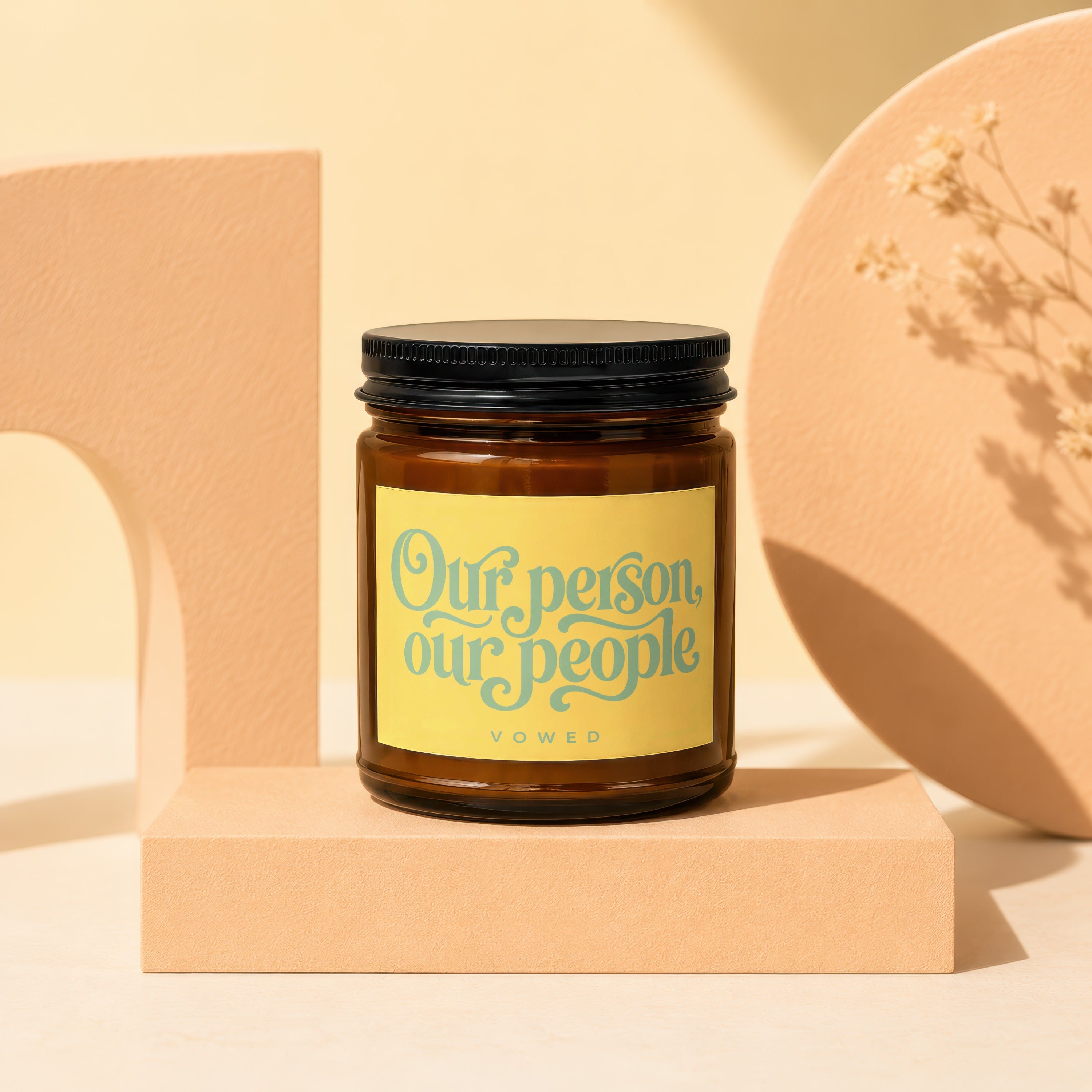 Amber jar candle with yellow label that reads "Our person, our people" and "vowed".