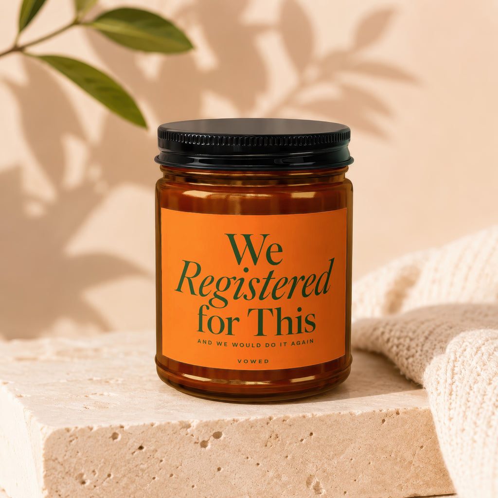 Candle with orange label that reads "We Registered for This" and "Vowed".