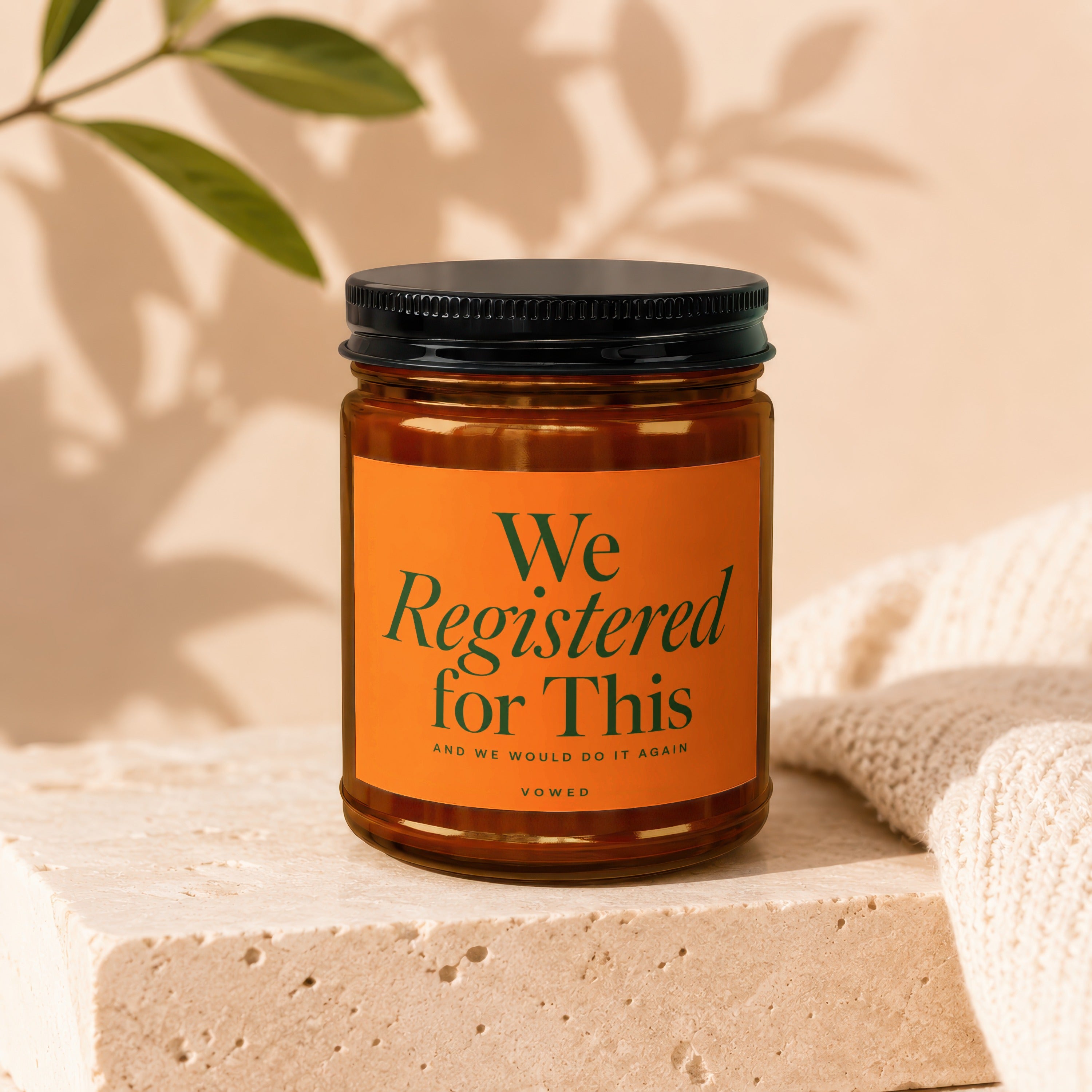 Candle with orange label that reads "We Registered for This" and "Vowed".