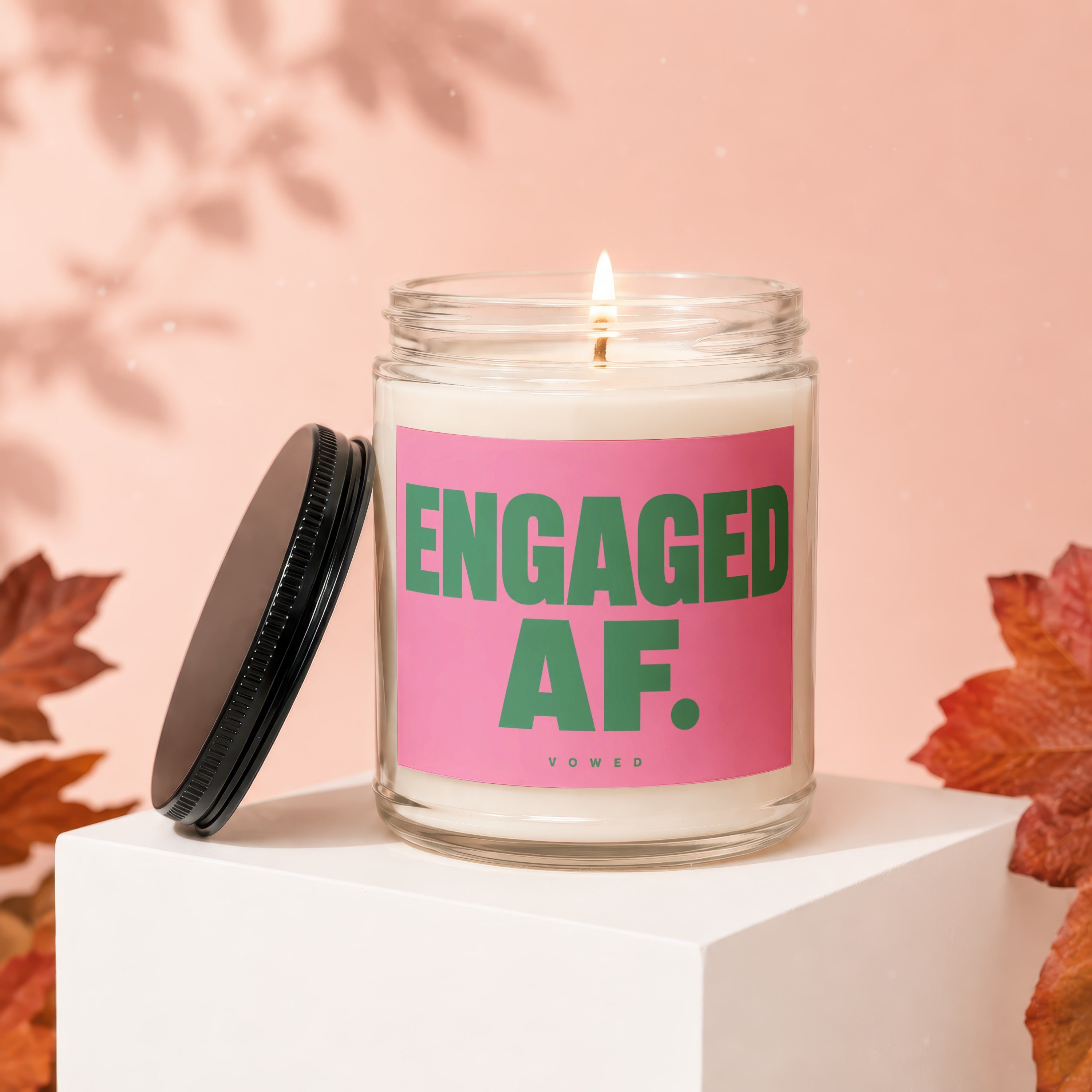 Glass candle with "ENGAGED AF." and "VOWED" text on a pink label.