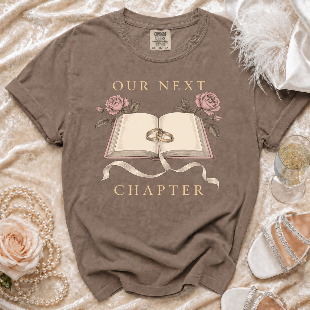 Brown t-shirt with "Our Next Chapter" text, open book, rings, and roses graphic.