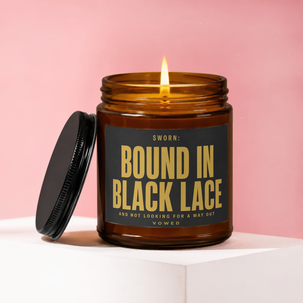 Amber jar candle labeled "SWORN: BOUND IN BLACK LACE AND NOT LOOKING FOR A WAY OUT".